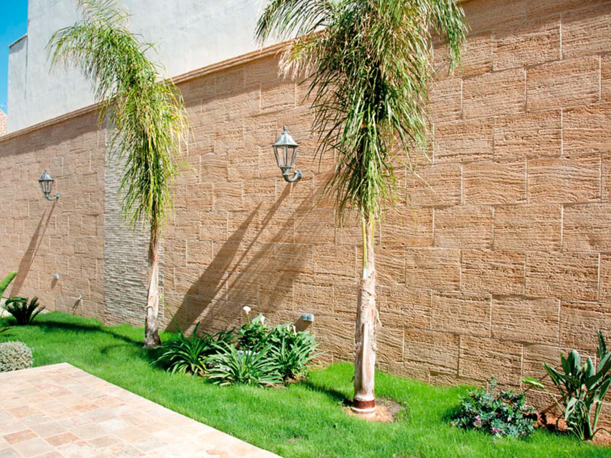 Pared exterior con revestimiento que imita piedra travertino arenado