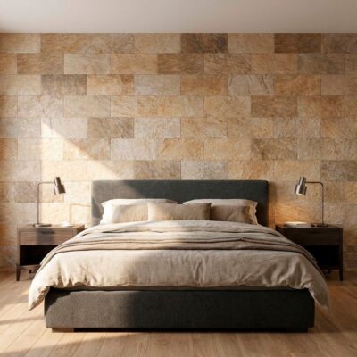 Dormitorio con pared de revestimiento imitación piedra cuarzo en tonos beige y marrón, cama tapizada gris oscuro, mesitas de madera y suelo de parquet. El acabado del revestimiento presenta textura natural con variación de color en formato rectangular.