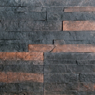 Mosaico de baldosas rectangulares en gres porcelánico imitación piedra con acabado mate. Alterna tonos gris oscuro y marrón rojizo en formato de pared, mostrando la variación cromática y textura natural del material.