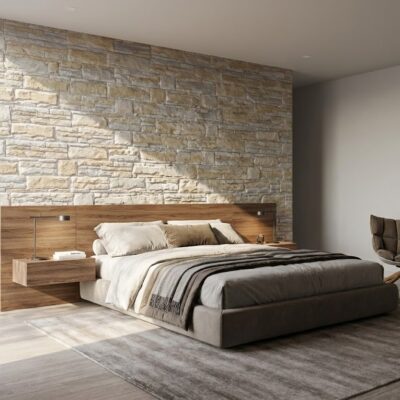 Dormitorio contemporáneo con pared de aplacado imitación piedra beige Saqqara, cabecero de madera integrado con iluminación, cama tapizada gris oscuro y suelos porcelánicos de tonalidad clara.