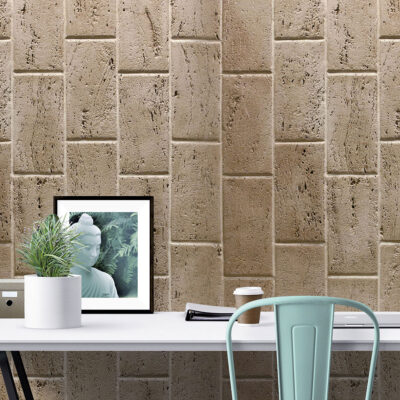 Espacio de trabajo contemporáneo con pared de revestimiento en piedra travertino tono olivillo oscuro en formato rectangular. Escritorio blanco minimalista con silla verde menta, maceta blanca y marco decorativo complementan el diseño.