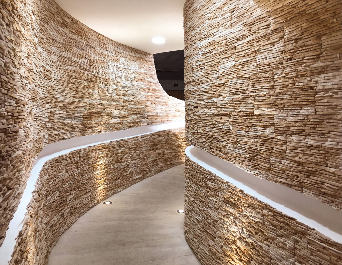 Comedor con pared de imitación piedra en tonos cálidos