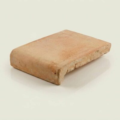 Peldaño rectangular de barro natural con superficie texturizada y acabado mate. Pieza de barro cocido en tonos tierra cálidos con ligeras variaciones de color y porosidad visible característica del material artesanal.