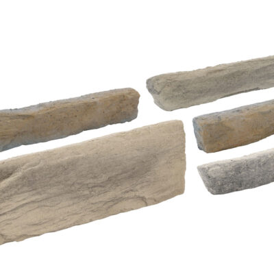 Cinco piezas de revestimiento en hormigón con acabado perlado en tonos beige y gris. Incluye una pieza rectangular grande y cuatro piezas más pequeñas de formato irregular con bordes rústicos y textura rugosa.