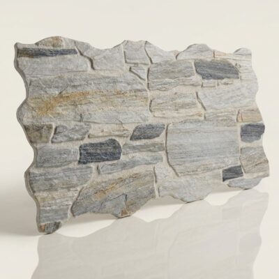 Plaqueta de hormigón con efecto piedra natural en tonos grises y beige, formato irregular apilado, textura rugosa y acabado mate. Suelo cerámico con detalle de estratificación.