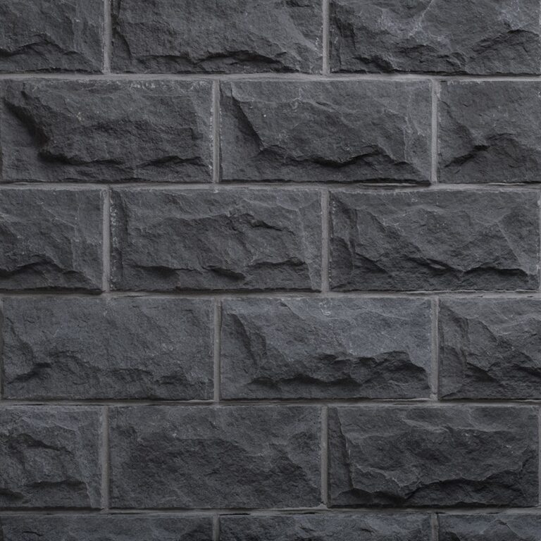 Superficie de plaqueta imitación piedra basalto con textura rústica irregular y acabado mate gris oscuro, mostrando relieve natural y variaciones de tonalidad en toda la cara visible.