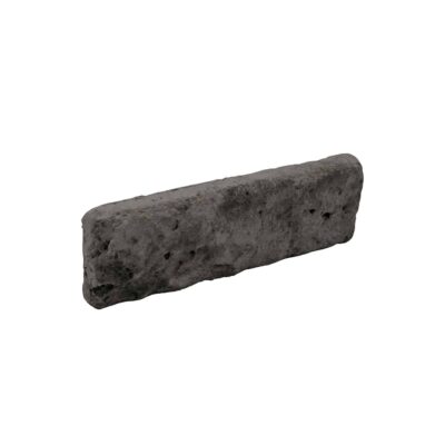Pieza rectangular de revestimiento en hormigón con acabado texturizado imitando ladrillo, color gris oscuro a negro con poros y variaciones de superficie típicas del material.