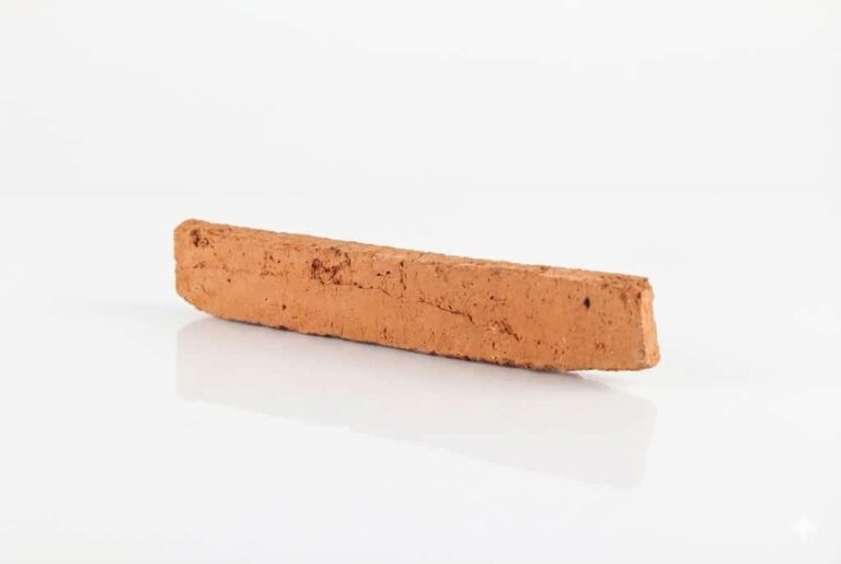 Pieza rectangular de revestimiento rústico en tonalidad terracota destonificada, con textura superficial rugosa y acabado mate. Superficie con variaciones de color y porosidad característica del barro cocido.
