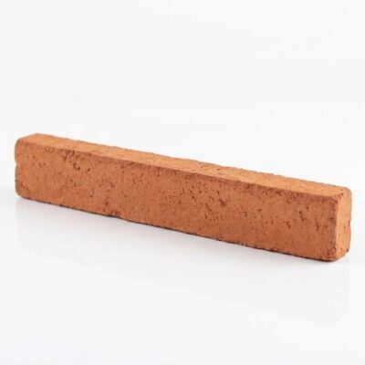 Pieza rectangular de ladrillo cerámico rústico en tonos rojos y naranjas, con textura rugosa y acabado mate. Material tradicional para revestimiento de pared.