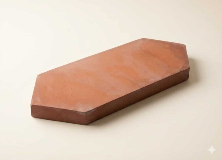 Pieza de barro cocido mecanizado con forma romboidal y superficie plana color arena. Formato rectangular alargado con acabado mate y tonalidad cálida característica de la terracota.