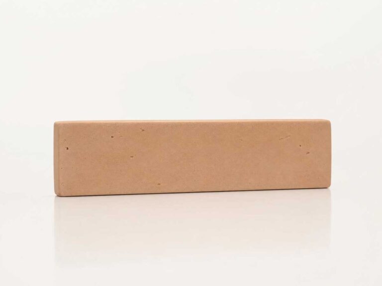 Pieza rectangular de zócalo de barro en tonalidad beige-marrón con textura rústica y acabado mate. Formato alargado con bordes redondeados, ideal como suelo cerámico de transición.